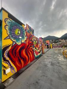mural dwóch kotów namalowany na boku budynku w obiekcie Casa Campus IVIN Chapinero w mieście Bogota