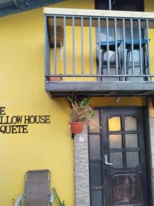 a yellow house with a balcony and a door at The Yellow House Boquete (hostal) in Alto Boquete