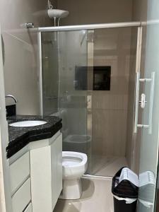 een badkamer met een toilet en een glazen douche bij Mini mansão in Montes Claros