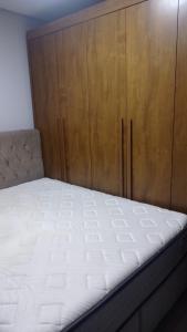 een slaapkamer met een bed en een houten kast bij Mini mansão in Montes Claros