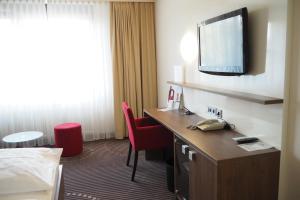 a hotel room with a desk and a television at Hotel Fuchsen in Kirchheim unter Teck