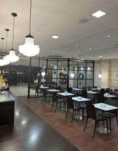 un comedor con mesas, sillas y luces en Hotel Alvear, en Montevideo