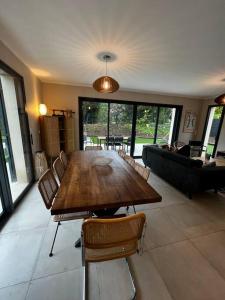 ein Wohnzimmer mit einem Holztisch und Stühlen in der Unterkunft Belle maison 4* Clim Piscine Wifi in Gassin