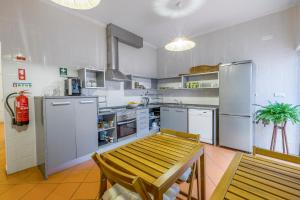 a kitchen with a wooden table and a refrigerator at Casa Luma B&B in Lagos