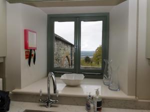 eine Küchentheke mit Spüle und Fenster in der Unterkunft Rowan Cottage in Ulverston + 60 Fotos