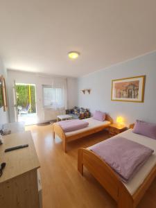 Habitación grande con 2 camas y mesa. en Cozy Room with garden in Bratislava, en Bratislava