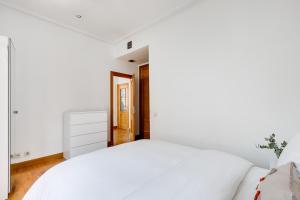 een witte slaapkamer met een groot wit bed bij Serrano & Claudio Coello: Lujo, Luz y Elegancia in Madrid