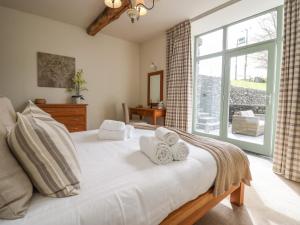 ein Schlafzimmer mit einem großen Bett mit Handtüchern darauf in der Unterkunft Rowan Cottage in Ulverston