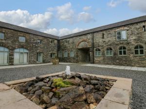 ein Steingebäude mit einem Brunnen davor in der Unterkunft Rowan Cottage in Ulverston