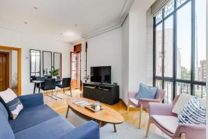 a living room with a blue couch and chairs at Serrano & Claudio Coello: Lujo, Luz y Elegancia in Madrid