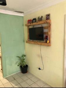 a living room with a tv on a wall at Traveler gu's room AP compartilhado in Fortaleza