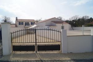 Maison de vacances saisonnier في نوتر دام دي مونتس: حاجز أبيض مع بوابة أمام المنزل