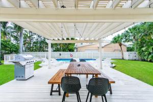 a patio with a table and chairs and a grill at Walk to Beach Luxury 5BR & 3BA Villa Hollywood Lakes in Hollywood