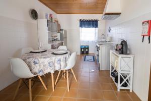 a kitchen with a table and chairs in a room at Casa do Furtadinho in Madalena