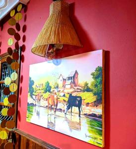 a painting of a cow on a wall with a lamp at L'anis Etoilé - Hôtel Restaurant in Antsirabe