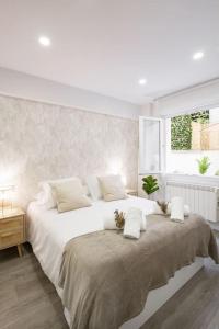 een witte slaapkamer met een groot bed en een raam bij El Patio de Schulz in Gijón