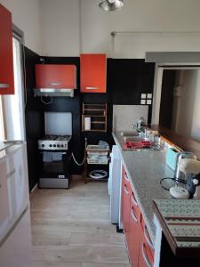 - une cuisine avec des armoires orange et noire et un évier dans l'établissement Le bon séjour, à Marseille