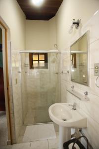 a white bathroom with a shower and a sink at Apoena Chales da Ilha in São Francisco Xavier +52 photos