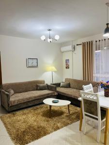 een woonkamer met een bank en een tafel bij ALBI’S Apartment in Tirana