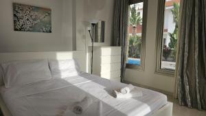un letto bianco in una stanza con finestra di STAY Sunset Lagoon Villa a Pyla