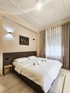 Un dormitorio con una cama grande con dos toallas encima. en Sunflower Junior Suite, en Tirana