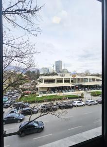 Un estacionamiento con autos estacionados frente a un edificio. en Sunflower Junior Suite, en Tirana 7 fotos más