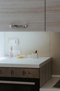 a kitchen with a white counter top and wooden cabinets at A due passi dal mare - Oasi di pace in Petacciato