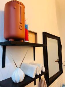 łazienka z lustrem i ręcznikami na półce w obiekcie Makini Spaces w mieście Arusza