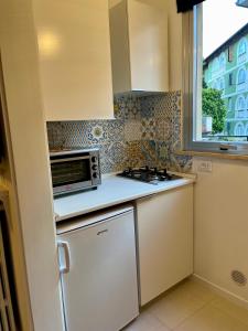 uma pequena cozinha com um micro-ondas e um frigorífico em mineVaganti em Ancona