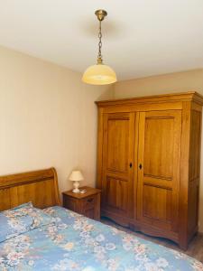a bedroom with a bed and a wooden cabinet at Oasis urbaine appartement 2 pièce in Nice