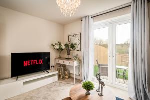 a living room with a tv and a sliding glass door at Poppy House - Coastal Getaway 2 Bedroom in Scalby in Scalby
