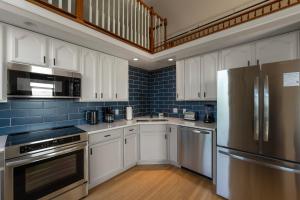 een keuken met witte kasten en een roestvrijstalen koelkast bij Mason's View - Cincy Hilltop Apartment in Cincinnati