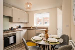a kitchen and dining room with a table and chairs at Poppy House - Coastal Getaway 2 Bedroom in Scalby in Scalby