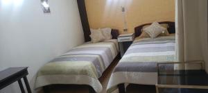 a bedroom with two beds and a glass table at Casa Qura Qura in Cochabamba