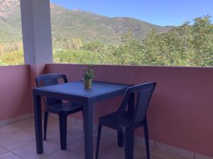 a blue table and chairs on a balcony with a view at Hotel Golfo del Leone in Portixeddu