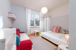 Villa Christiane App_ 3 في هيرينجسدورف: غرفة معيشة بها سريرين وأريكة حمراء