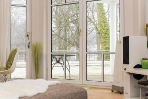 1 dormitorio con puertas correderas de cristal y vistas a un patio en Villa Christiane App_ 3 en Heringsdorf