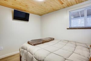 1 dormitorio con 1 cama y TV de pantalla plana en Updated Wellston Cabin Near Boating and Fishing!, en Irons