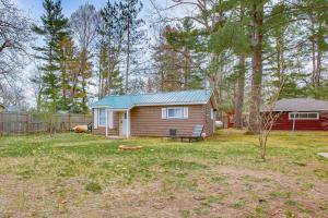 una pequeña casa con un banco en un patio en Updated Wellston Cabin Near Boating and Fishing!, en Irons