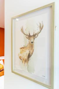 une peinture d'un cerf dans un cadre sur un mur dans l'établissement New corner studio apartment in Sheffield, à Sheffield