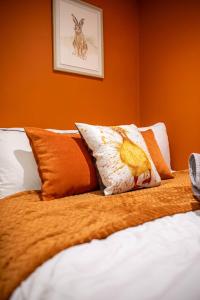 a bed with orange and white pillows on it at Corner studio apartment in Sheffield in Sheffield