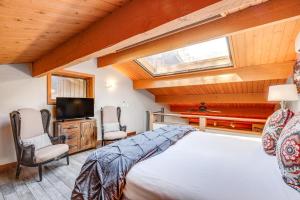1 dormitorio con 1 cama, 2 sillas y TV en Junipine Resort Townhome with Deck and Canyon Views! en Munds Park