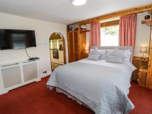 a bedroom with a large bed and a flat screen tv at The Nook in Llanrwst