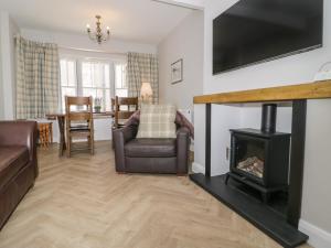 uma sala de estar com um sofá e uma lareira em Oriel Cottage em Conwy