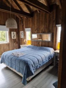 a bedroom with a bed with a blue blanket at Chapa Pituca Boutique in San Martín de los Andes