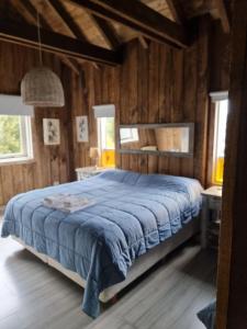 1 dormitorio con 1 cama con manta azul en Chapa Pituca Boutique en San Martín de los Andes