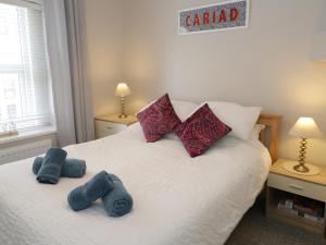 a bedroom with a bed with two stuffed animals on it at Oriel Cottage in Conwy