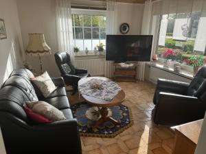 sala de estar con sofá, sillas y mesa en Schwalbenhof, en Westerstede