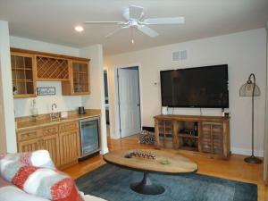 a living room with a table and a flat screen tv at Peachbrook, Llc in Brant Beach