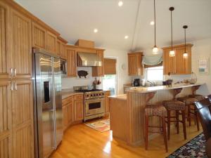 a kitchen with wooden cabinets and a stainless steel refrigerator at Peachbrook, Llc in Brant Beach